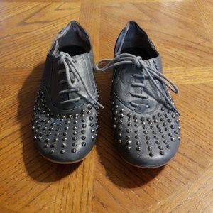 Dark gray lace up shoes with metal studs.